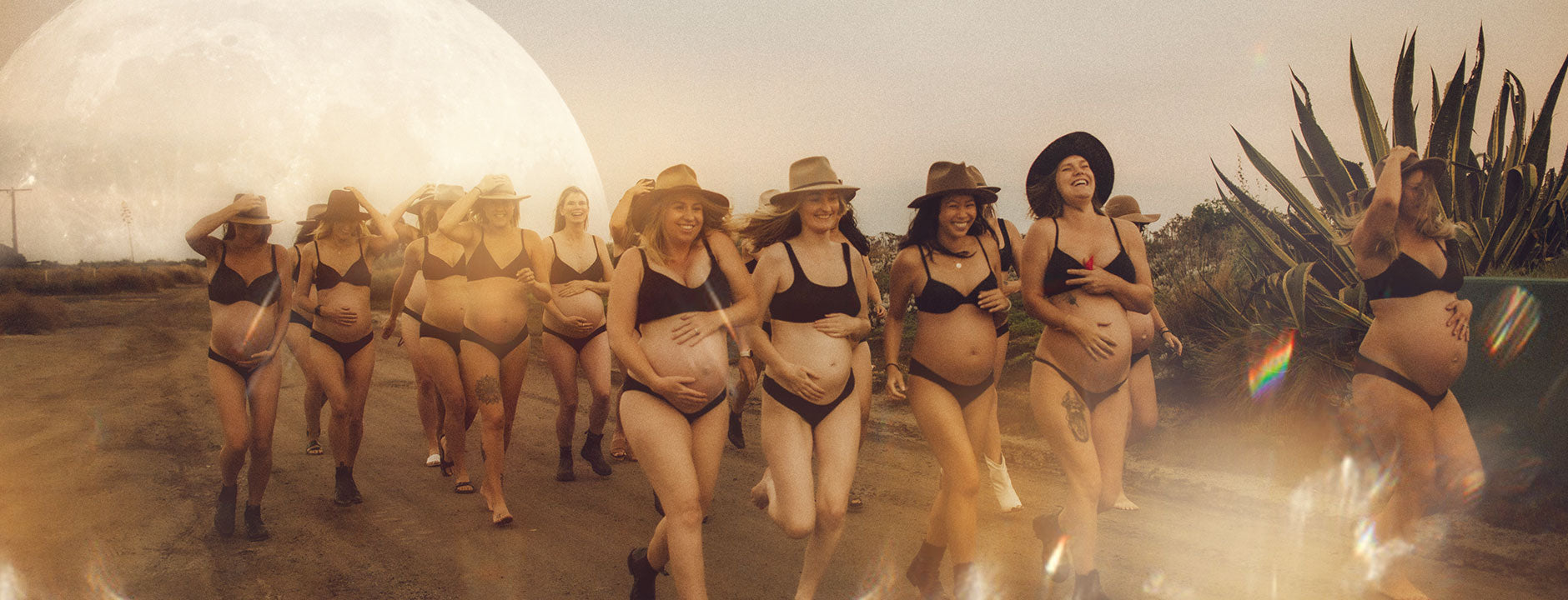 Laughing pregnant women walking down a road barefoot